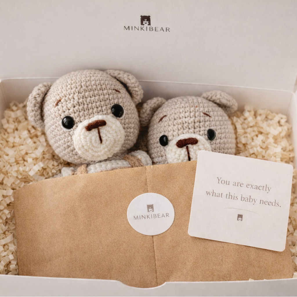 Crocheted teddy bear and rattle set inside MINKIBEAR white gift box with ivory crinkle paper